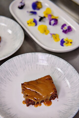 Elegant dessert garnished with edible flowers on a porcelain plate