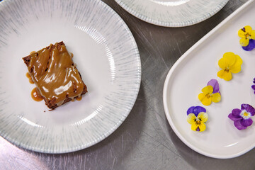 Elegant dessert garnished with edible flowers on a porcelain plate