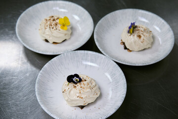 Elegant dessert garnished with edible flowers on a porcelain plate