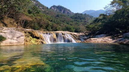 Fototapeta premium Mountain waterfall cascading into tranquil pool, lush green forest backdrop