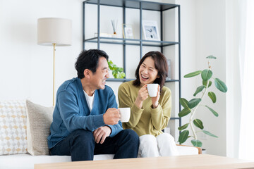 リビングでくつろぐミドルの夫婦