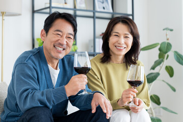 リビングでワインを飲むミドルの夫婦