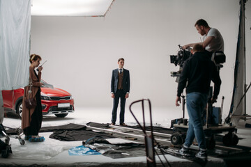 Filming location. Filming a commercial in a pavilion. The film crew at work, an actor in the frame,...