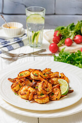 Grilled shrimp on a white plate with lime