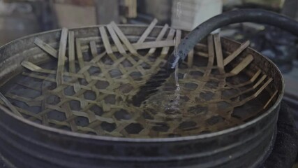 Water cooldown for a traditional Laotian rice whiskey process, locally produced spirits. 4k video footage