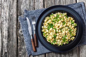 Pasta with green peas in a bowl, italian cuisine