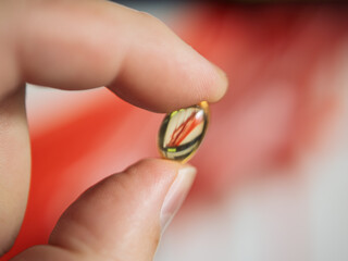 Delicate Hand Holding a Colorful Glass Marvel