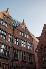 Fototapeta premium An upward view of distinctive gabled red brick buildings in Böttcherstraße, a famous street in Bremen, Germany.