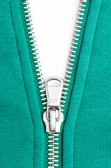 White background under unzipped steel zipper on green sweatshirt © kosoff