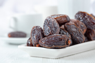 Dried medjool dates on a white table.