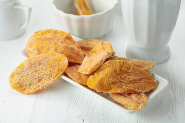 Dried mango slices on a white table.