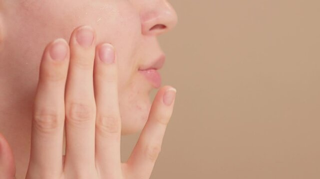 Woman performing anti-aging facial massage after applying serum and cream. Boosts skin elasticity, reduces fine lines, and promotes youthful, glowing skin. Relaxing self-care massage routine. Skincare