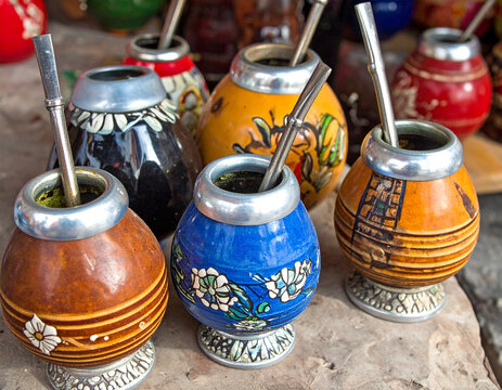 Colorful ceramic mate gourds with unique designs, showcasing the artistic variations and personal expression associated with this Argentine tradition.