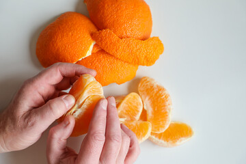 On a kitchen wooden cutting board lies a ripe bright large orange, and next to it is a knife and a ripe pineapple © Svitlana