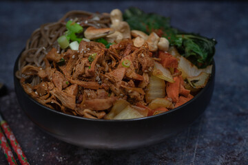 Vegan Korean noodle and jackfruit bowl with carrot and bok choy, bibimbap