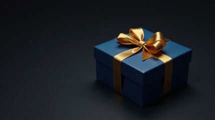 Obraz premium A luxuriously wrapped present, dark blue box with a golden ribbon, sits on a dark surface
