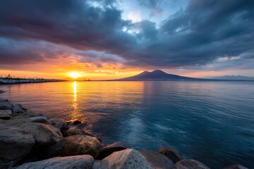 Vibrant sunset reflecting over calm water with distant mountain view
