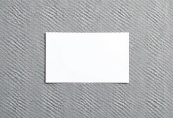 Crisp white card blank on textured grey fabric, clean, item