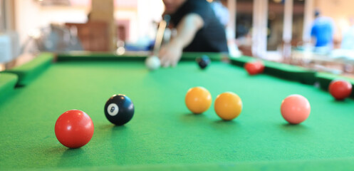 billiard poule close-up. Colorful balls on the green billiards table.Billiard balls with numbers on...