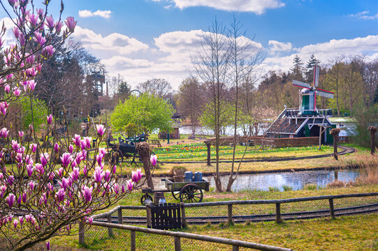 Scenic view of a scaled Dutch windmill and milk cart in amusement and theme park Efteling, The Netherlands.