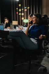 Dedicated team collaborates in an office, focusing on their tasks late into the evening. The atmosphere is energetic yet relaxed, showcasing modern business dynamics and technology-driven workspace.