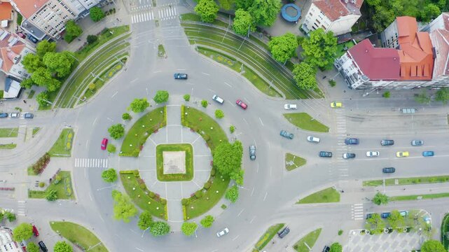 Establishing aerial footage of city streets with traffic and a monument on a roundabout