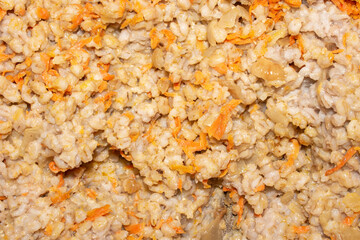 Pearl barley with onion and carrot texture.Pearl barley homemade view from above.Boiled pearl barley background.