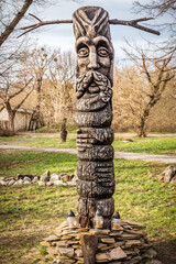 Slavic pagan idol forest in spring. A wooden statue, an image of a Slavic god. An attribute of...