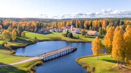 Fototapeta premium Serene autumnal village scene; golf course, lake, wooden bridge, church steeple, golden trees
