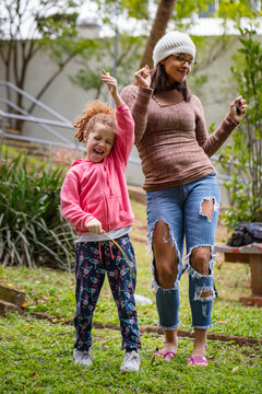 Red-haired girl playing on a sunny day with her mother