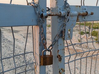 Padlock, Pad lock around the chain, Padlock on fence, Heavy metal padlock with chain closeup on an entrance gate. Safety, security concept.