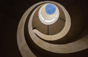 Fototapeta premium Spiral staircase, concrete, natural light, minimalist design, dramatic shadows.