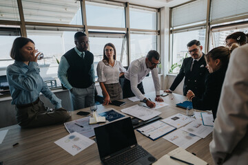 Diverse group of people collaborating in a modern office environment, focusing on financial charts...