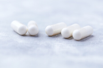 Creatine capsules on bright wooden background. Soft focus. Close up. Copy space.	