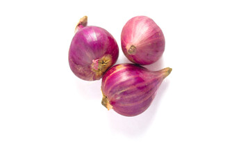 Three red onions with vibrant purple-red hues rest on a white surface. Their outer skins are...