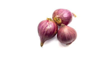 Three red onions with vibrant purple-red hues rest on a white surface. Their outer skins are intact, showcasing their natural texture and shape, with subtle brownish spots near the roots.