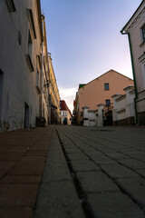 Paving stones in the old town. Evening, sunset sky. Facades of old buildings