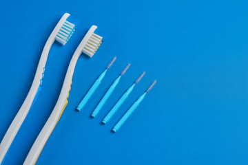 Toothbrushes and Dental Tools Arranged on a Blue Surface for Oral Hygiene Routine