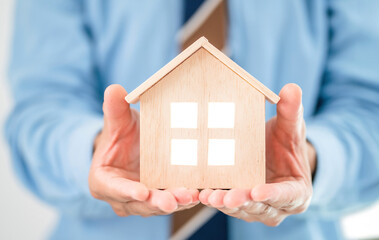 office male worker holding toy house showing stable life dream. man reveal wooden home suggest for...