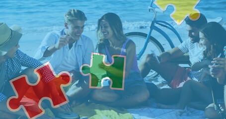 Image of colourful puzzle pieces and autism text over happy friends using tablet in beach
