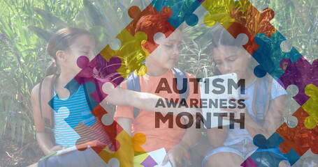 Image of colourful puzzle pieces and autism text over school children using tablets
