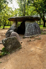 Prehistoric stone dolmen in a natural forest under daylight