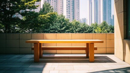 Fototapeta premium Wooden table on a sunny terrace with city skyscrapers in the background.