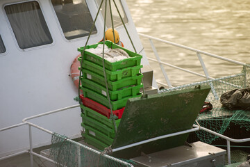 Sailor, manipulating crane controls to unload the load of fish