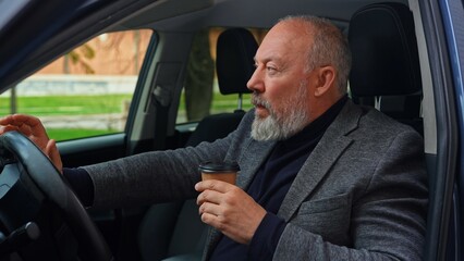 Elderly Man Drinking Coffee in Car Drivers Seat