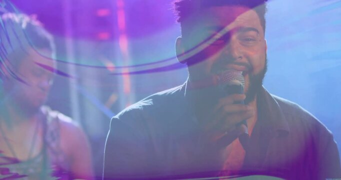 Bearded singer singing into mic and guitarist strumming on stage with motion waves in music