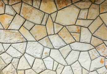 The photo shows a wall facade lined with brown stones of various shapes