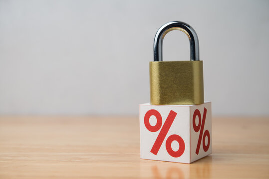 Padlock on percentage sign (interest rate) with white wall background. Interest rate locked in banking, financial and investment, profit locked no price increase in trading and fixed cost concept.