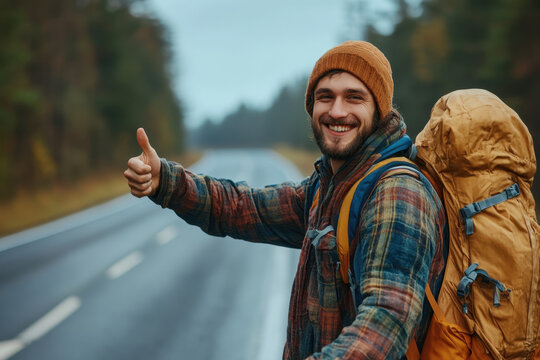 Man with backpack giving thumbs up on road.