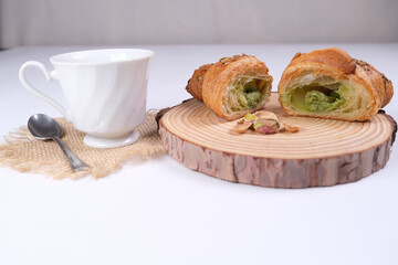 Tagliere con brioche alla crema di pistacchio e tazza di caffè sul tavolo 